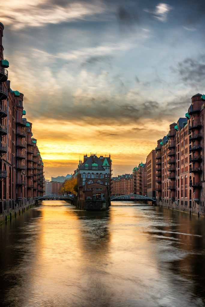 10231225 - Sonnenuntergang am Wasserschloss | Das Wasserschloss in der Speicherstadt vor einem leuchtenden Abendhimmel.