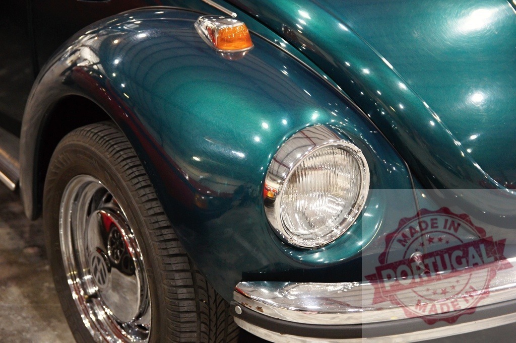 Shiny turquoise Volkswagen Beetle fender, headlight, and tire detail | Close-up of a polished turquoise Volkswagen Beetle, highlighting its fender, headlight, and tire in a showroom setting - Realisiert mit Pictrs.com