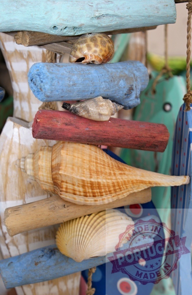 Close-up of nautical wind chime with shells and driftwood | Nautical wind chime featuring various seashells and colorful painted driftwood pieces - Realized with Pictrs.com