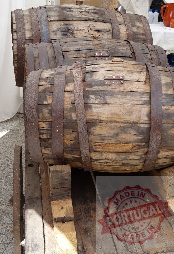 Old wooden barrels stacked on rustic cart | Old wooden barrels secured with rusty metal hoops storing liquid on a vintage wooden cart - Realisiert mit Pictrs.com