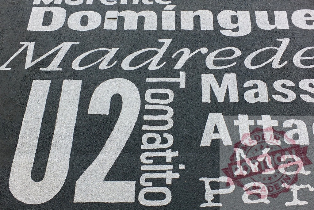 U2 and Massive Attack names on a music wall | Music artists names painted with white typography on a dark wall background - Realized with Pictrs.com