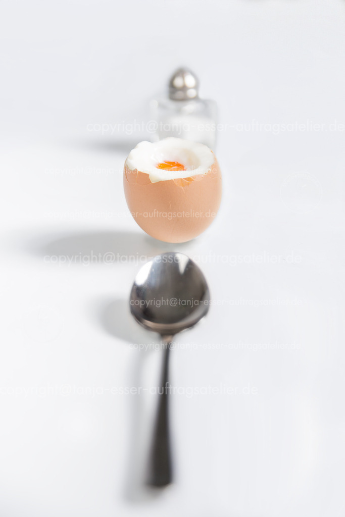 Fruehstuecks Ei D | Ei zum Frühstück mit Salzstreuer und Löffel auf weißem Hintergrund.
Die Mahlzeit ist hinter einander in eine Reihe angeordnet. 