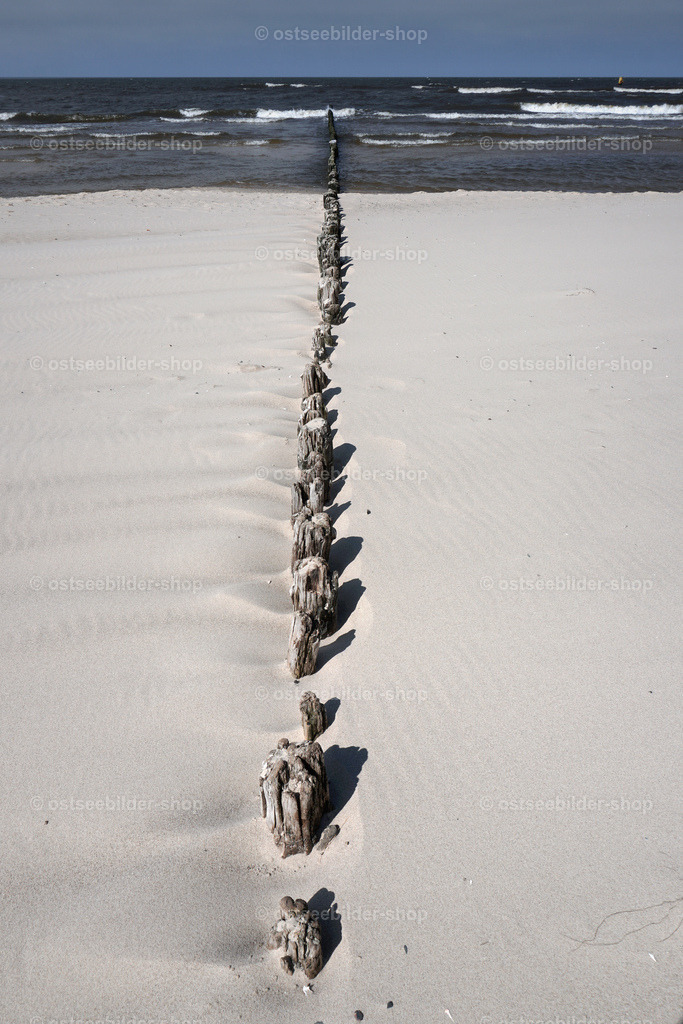 Winzige Reste einer alten Holzbuhne im Sand | Von der Brandung abgeschliffene Pfähle einer hölzernen Buhne ragen knapp aus dem Sandstrand von Misdroy hervor.
