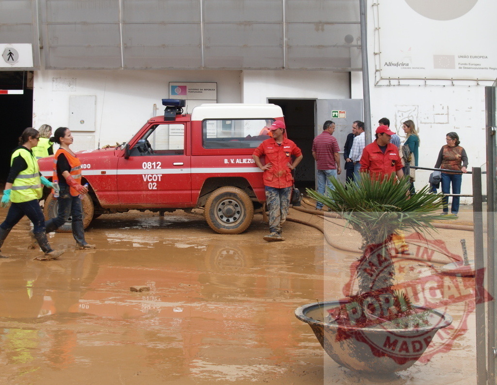 Emergency workers cleaning muddy debris following a natural disaster | Albufeira Flood - discruction by weather problems People and firefighters cleaning mud after flood disaster in Albufeira - Realized with Pictrs.com