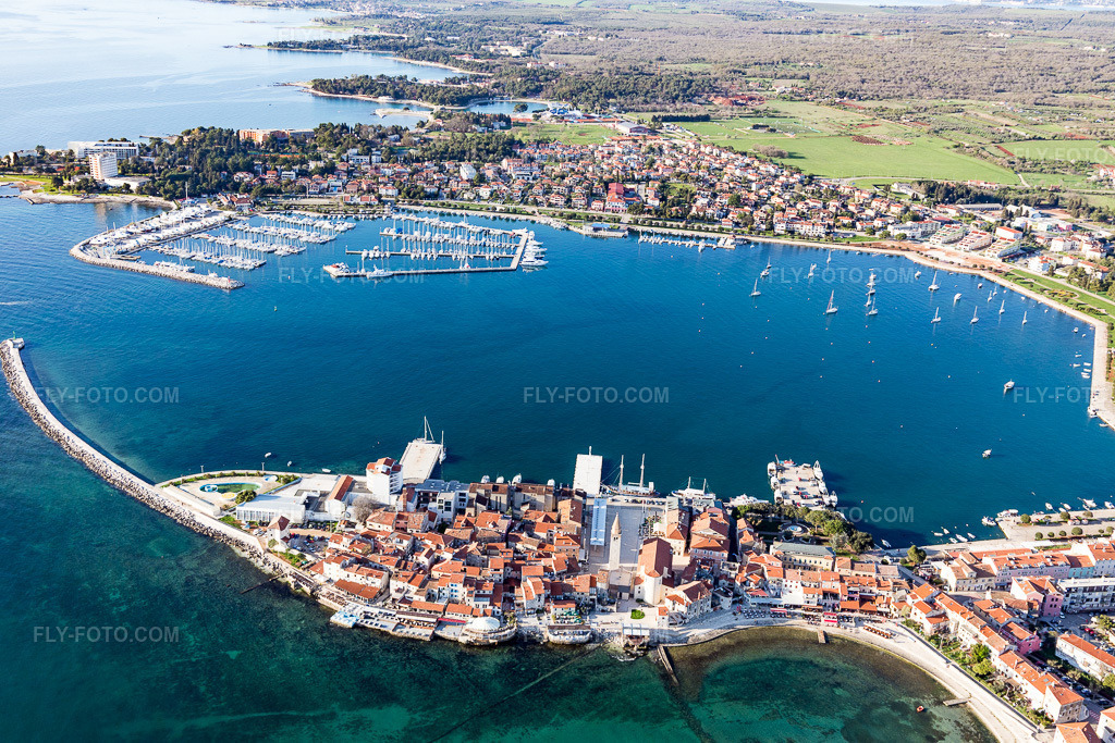 Aerial view: Marina with moorings and boat slips on the shore in the Adriatic bay in Istria - Istarska zupanija in Umag in the state Gespanschaft Istrien, Croatia. – Photo: IMG_106108.jpg taken on 04/13/2018 by Werner Riehm/FLY-FOTO.com – Resolution of the original: 5472 x 3648 px