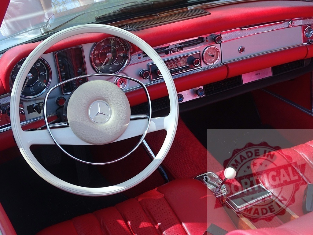 Mercedes-Benz classic car red leather interior dashboard | Mercedes-Benz vintage car interior featuring a white steering wheel, red leather dashboard, and seats - Realized with Pictrs.com
