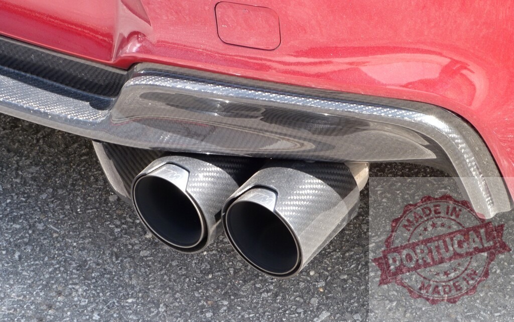 Red sport car featuring aggressive carbon fiber dual exhaust | Close-up of car rear showing carbon fiber exhaust tips and diffuser - Realisiert mit Pictrs.com