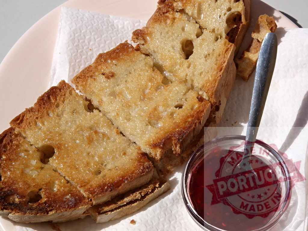 Toasted bread slices with melted butter and berry jam | Toasted bread slices offering a delicious breakfast with melted butter and raspberry jam - Realisiert mit Pictrs.com