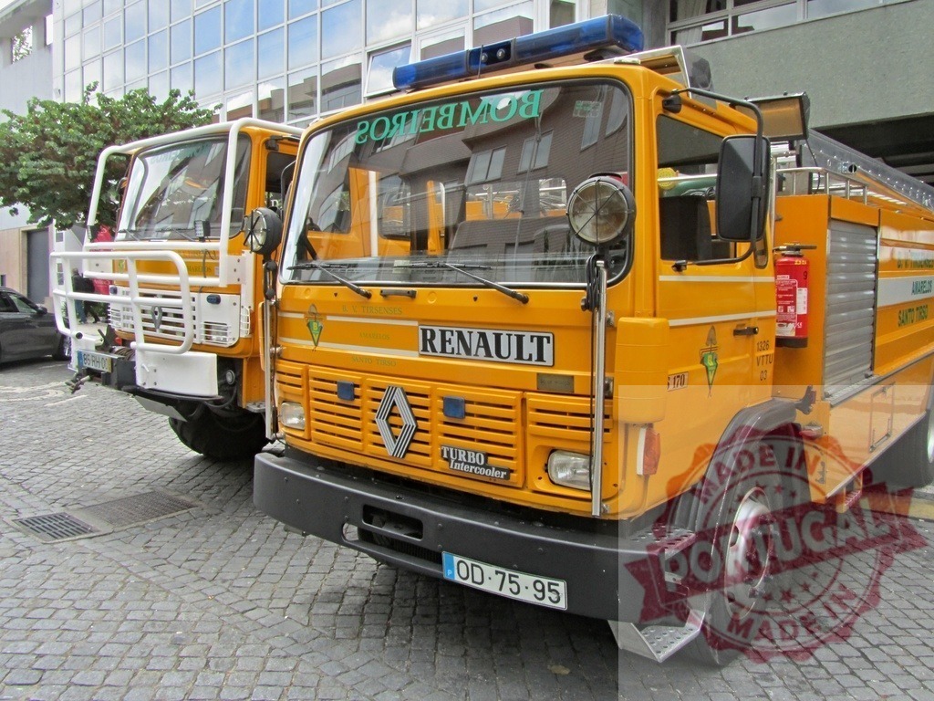 Yellow Renault fire trucks ready for emergency in Portugal | Yellow Renault fire trucks parked on a cobblestone street, prepared for emergency services - Realized with Pictrs.com