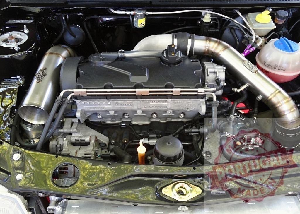 Volkswagen engine bay with custom turbo intake pipes | Modified car engine bay displaying custom turbo intake pipes and components - Realized with Pictrs.com