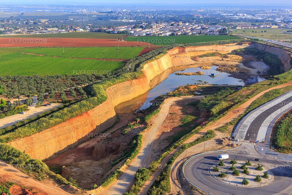 Aerial view: Gravel and sand pit in Dos Hermanas in the state Seville, Spain. – Photo: IMG_145764.jpg taken on 04/22/2025 by Werner Riehm/FLY-FOTO.com – Resolution of the original: 5053 x 3369 px