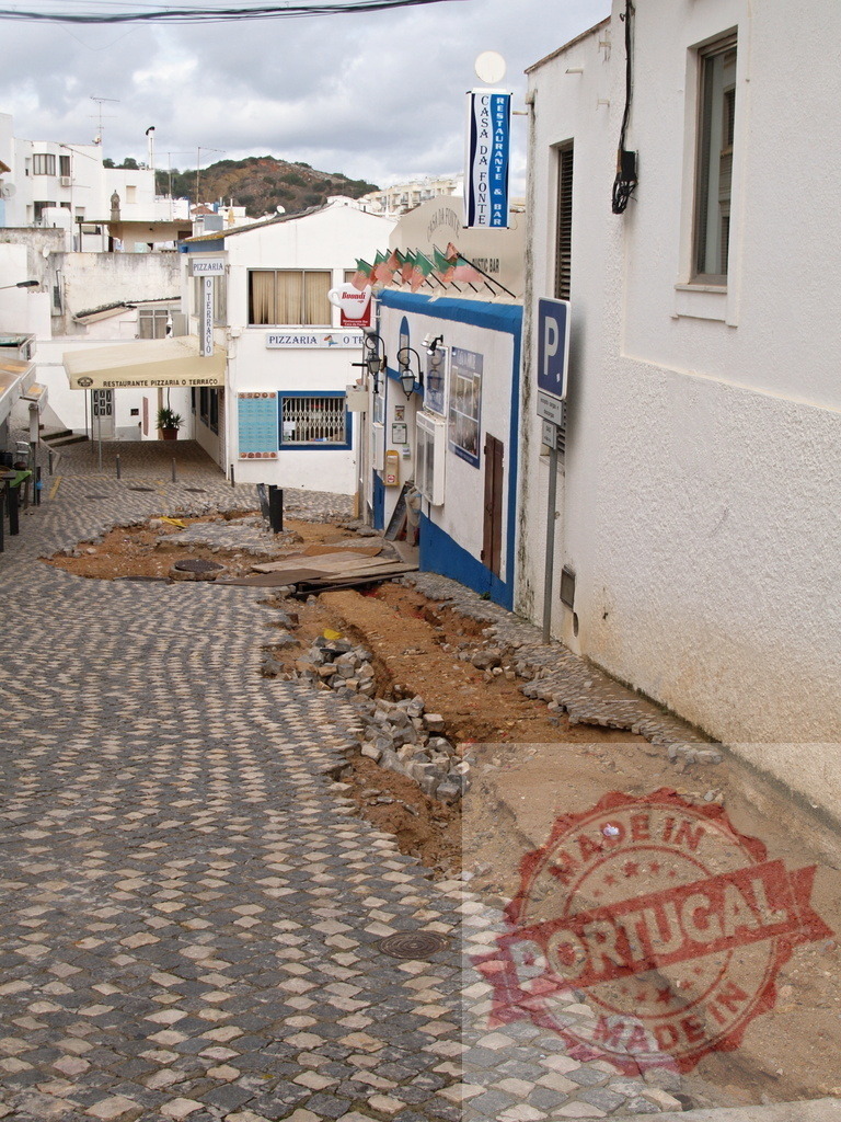 Cobblestone street undergoing construction in European town | Albufeira Flood - discruction by weather problems Pavement on a cobblestone street is being repaired in a European town - Realized with Pictrs.com