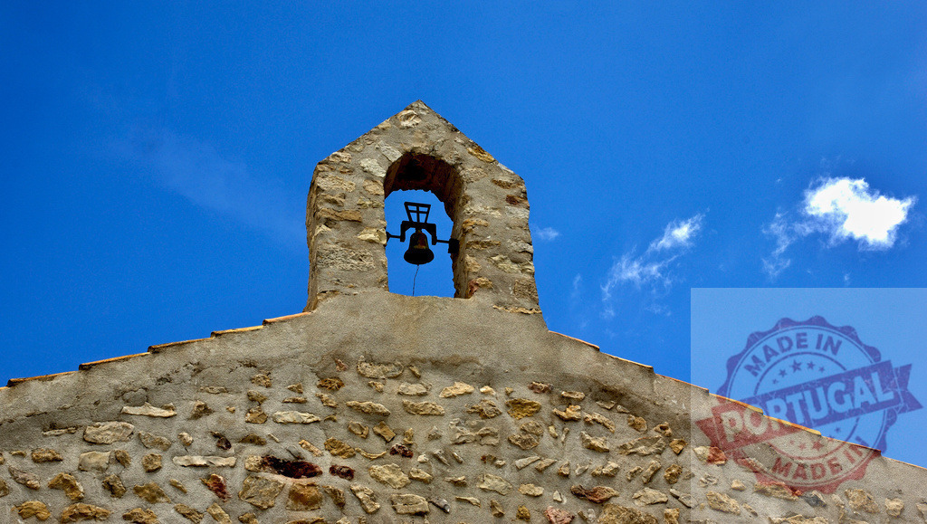 Old stone historic church bell tower against blue sky. Provincia Castellon - Spain | Stone bell tower from a historical church against a bright blue sky with a few clouds - Realized with Pictrs.com