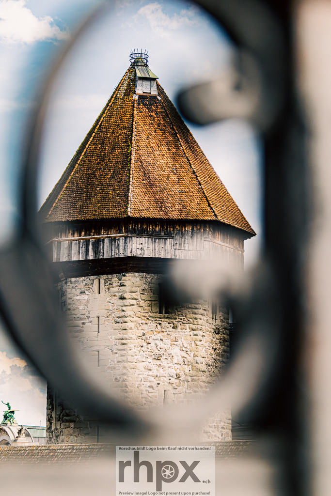 Wasserturm durch das Geländer / Water Tower through the Railing | Ein Blick durch das schmiedeeiserne Geländer auf den Luzerner Wasserturm – eines der bekanntesten Wahrzeichen der Stadt.  ***************A view through the wrought-iron railing toward Lucerne’s Water Tower — one of the city’s most iconic landmarks. The composition combines historic architecture with a unique perspective on this timeless scene. - Realisiert mit Pictrs.com