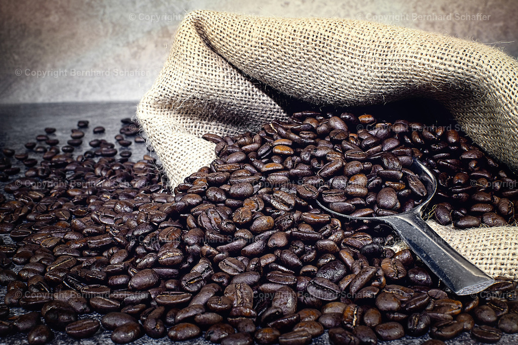 Kaffee im Sack | Ein Sack aus Sackleinen und dunkle Kaffeebohnen verstreut, mit einer Portionsschaufel. - Realisiert mit Pictrs.com