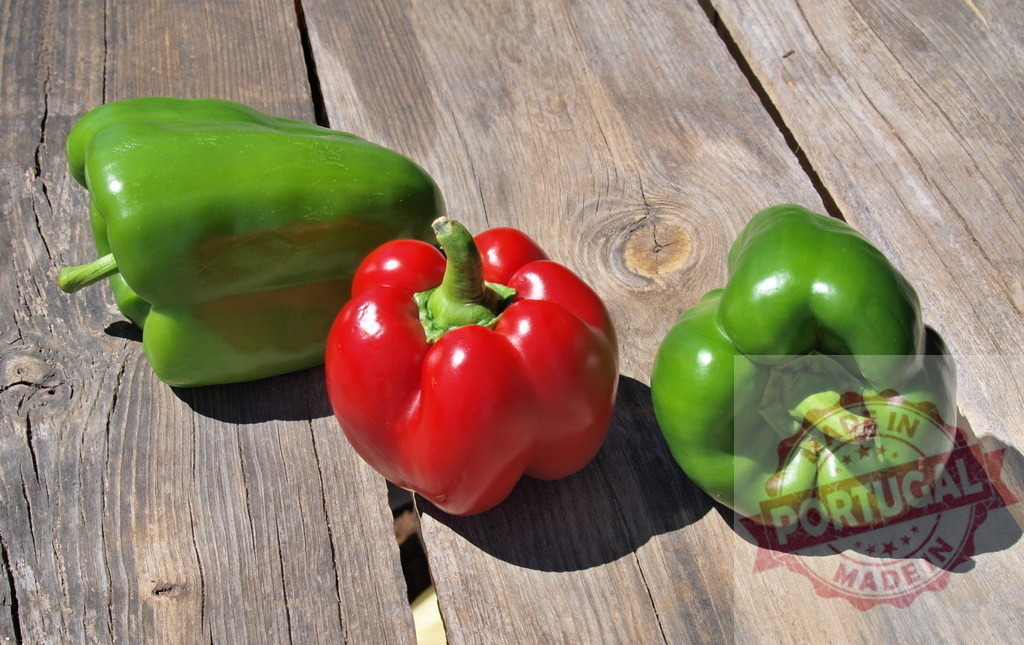 Fresh green and red bell peppers on rustic wooden table | Freshly picked bell peppers resting on an old wooden surface, showcasing organic produce - Realized with Pictrs.com