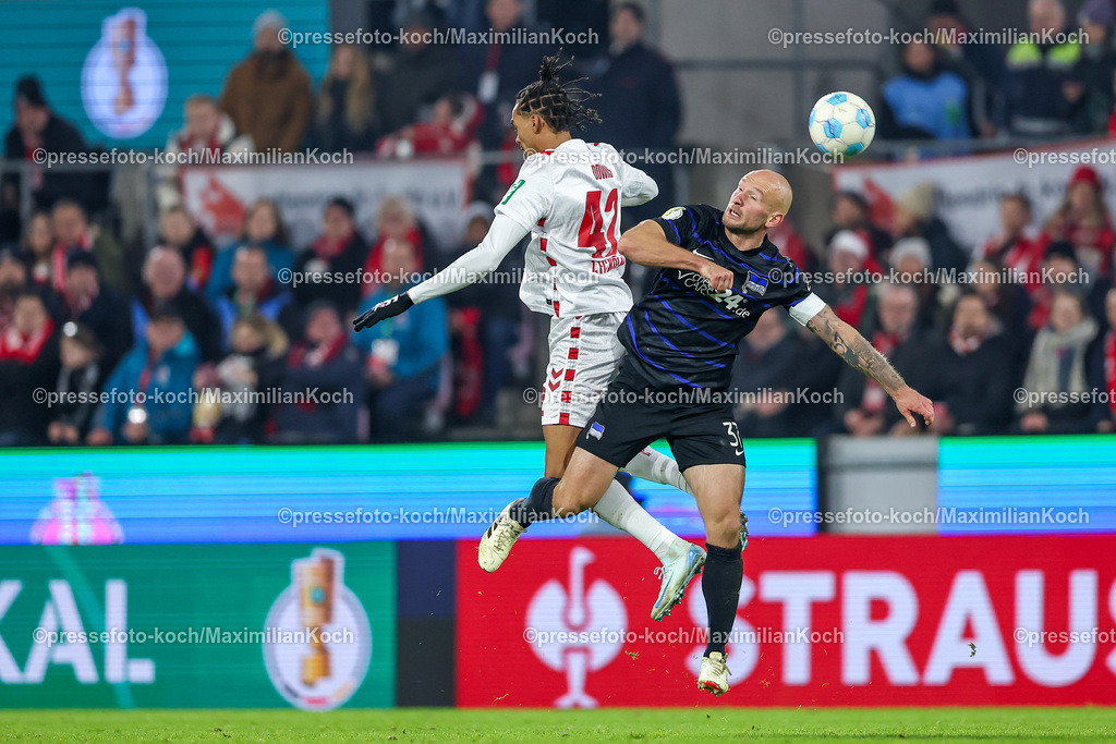 1FC04122402144 | 04.12.2024, Fußball, 1. FC Köln - Hertha BSC, Achtelfinale DFB-Pokal, RheinEnergieSTADION, Saison 2024 2025: Damion Downs (1.FC Köln #42) im Kopfball Zweikampf gegen Toni Leistner (Hertha #37)DFB regulations prohibit any use of photographs as image sequences and or quasi-video.