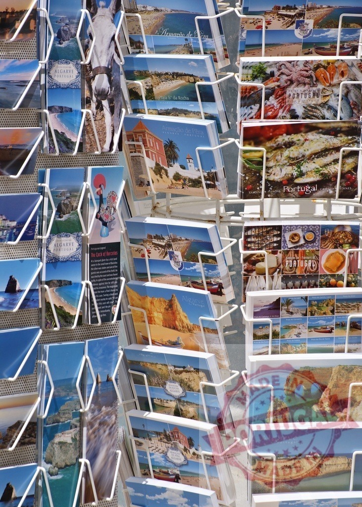 Postcards display featuring Algarve scenes from Portugal | Souvenir rack showcasing regional views and food for tourism - Realisiert mit Pictrs.com