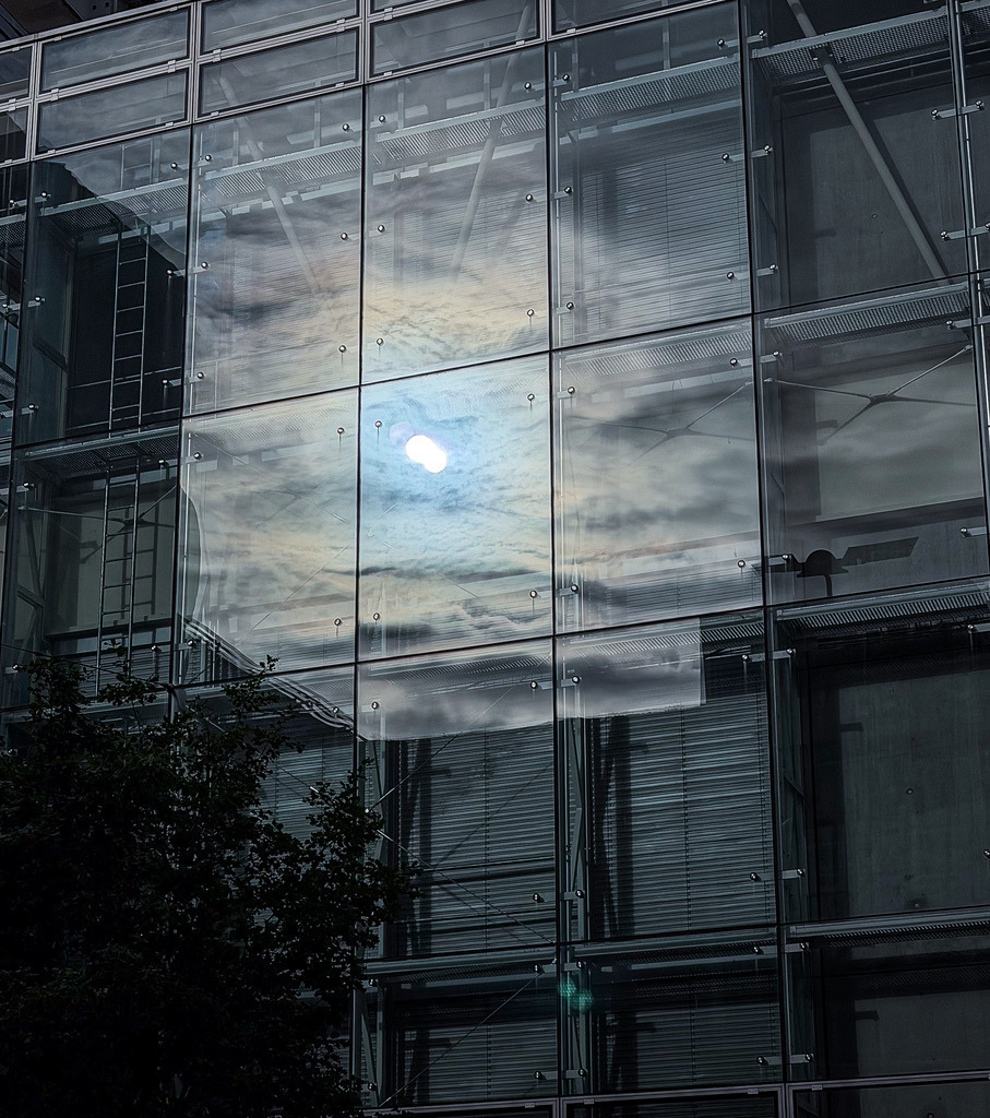 Basel Messeplatz – Fenster zum Himmel Architektur Spiegelung | Exklusive und minimalistische Architekturfotografie aus Basel: Dieses High-End Wandbild zeigt das ikonische Gebäude „Fenster zum Himmel“ direkt neben der berühmten City Lounge am Messeplatz. Die dramatische Lichtspiegelung in der modernen Glasfassade bricht die haptische, geometrische Rasterstruktur des Gebäudes faszinierend auf. Ein elegantes, kühles Kunstwerk in Galeriequalität – das perfekte Design-Statement für moderne Wohnräume, Lofts oder Büros auf Acrylglas und Alu-Dibond. - Realisiert mit Pictrs.com