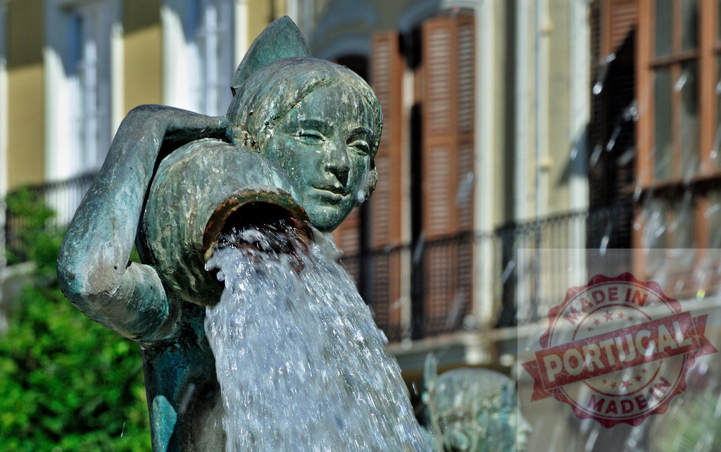 Bronze sculpture pouring water on historic city square | Bronze sculpture of a nymph pouring water from a pitcher, part of a public fountain creating refreshment - Realized with Pictrs.com