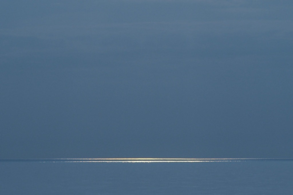 Abendsonne auf dem Meer | Durch ein Wolkenloch fallen Sonnenstrahlen auf das Meer - Realisiert mit Pictrs.com