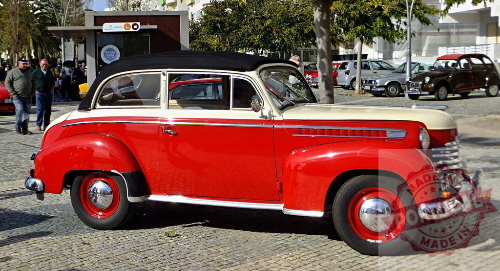 Shiny red and beige Opel Olympia Rekord cabriolet parked in Portugal | Restored Opel Olympia Rekord cabriolet parked on a cobblestone street in Portugal - Realized with Pictrs.com