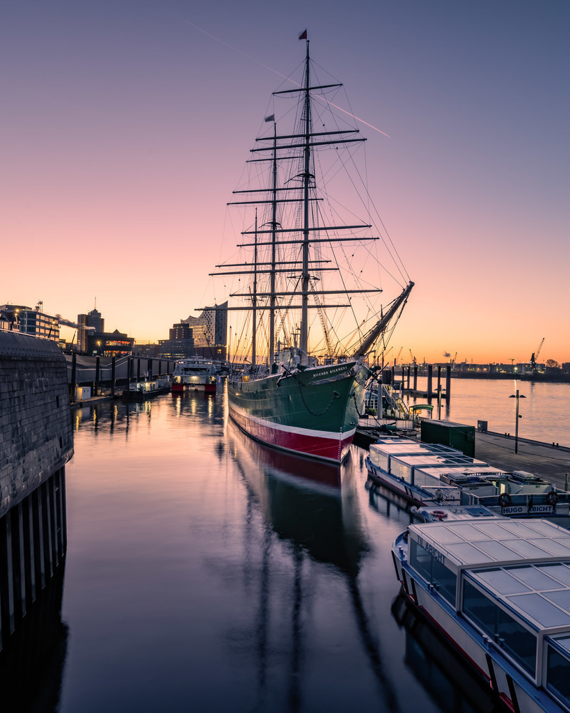 Segelschiff zur blauen Stunde – Hamburg | Ein historisches Segelschiff liegt ruhig im Hamburger Hafen, während die blaue Stunde Himmel und Wasser in kühle Farbtöne taucht. - Realisiert mit Pictrs.com