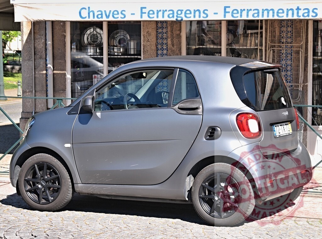 Smart Forfour compact car parked on European cobblestone street | Smart Forfour compact city car parked on a cobblestone street in front of a Portuguese storefront - Realisiert mit Pictrs.com