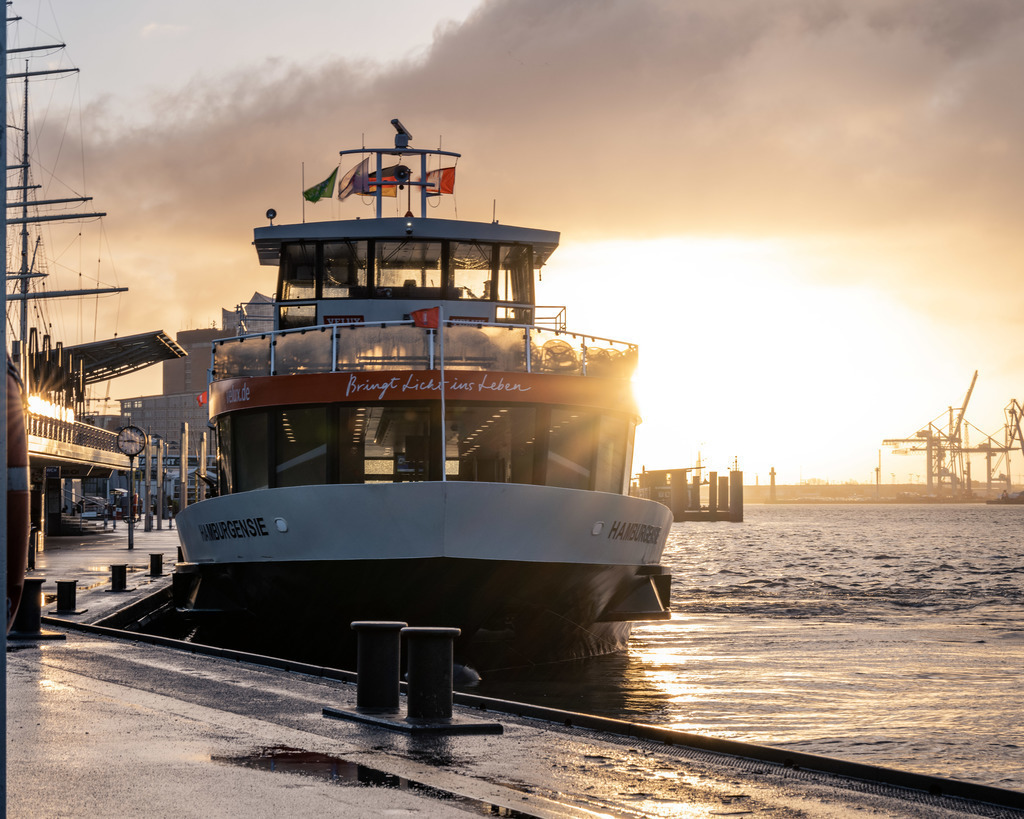 Hafenfähre im Gegenlicht – Hamburg | Eine Hamburger Hafenfähre frontal im warmen Gegenlicht – typisch für den Alltag auf der Elbe und zugleich ein markantes maritimes Motiv. - Realisiert mit Pictrs.com