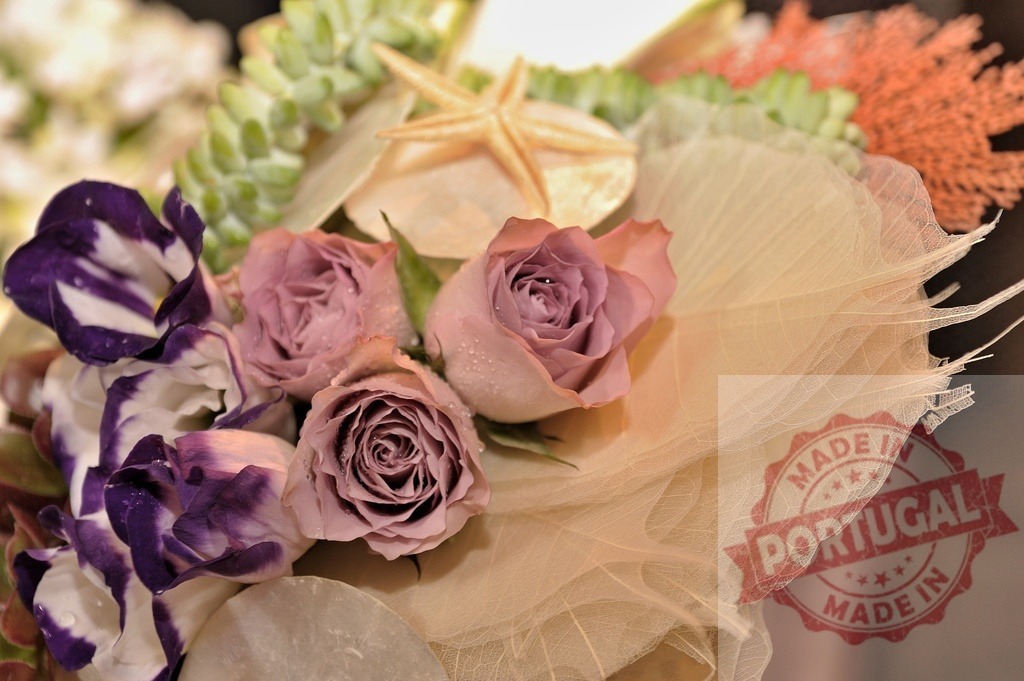 Delicate pink roses and purple lisianthus composing a bridal bouquet with decorative leaves and starfish | Close-up of a bridal bouquet featuring pink roses, purple lisianthus, starfish, and decorative leaves, creating a romantic arrangement - Realisiert mit Pictrs.com
