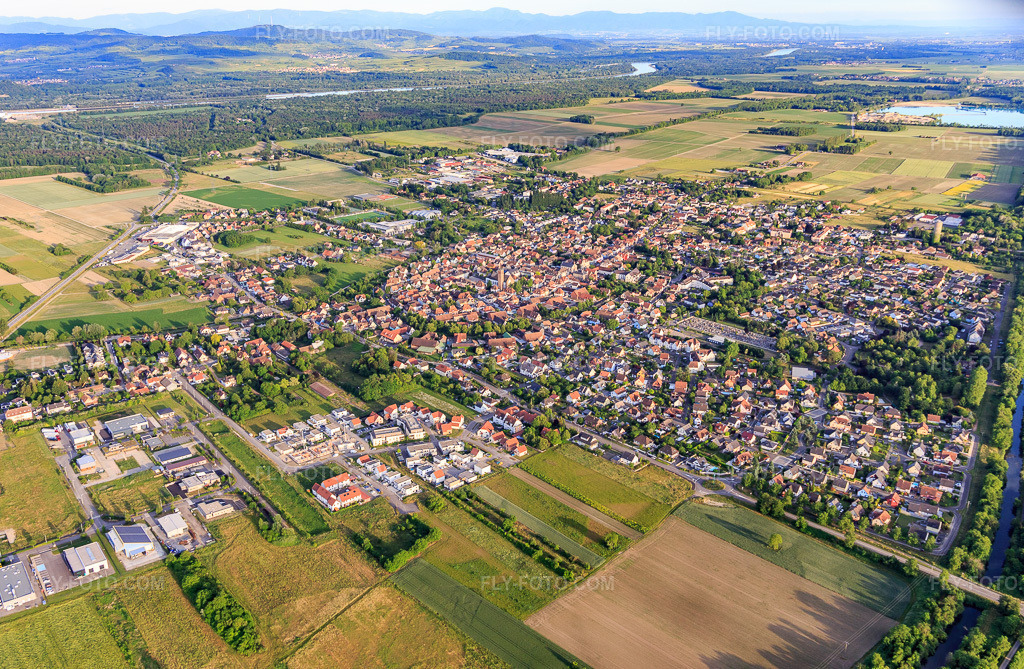 Aerial view: View of the town from the northwest in Marckolsheim in the state Bas-Rhin, France. – Photo: IMG_147372.jpg taken on 05/29/2025 by Werner Riehm/FLY-FOTO.com – Resolution of the original: 5136 x 3354 px
