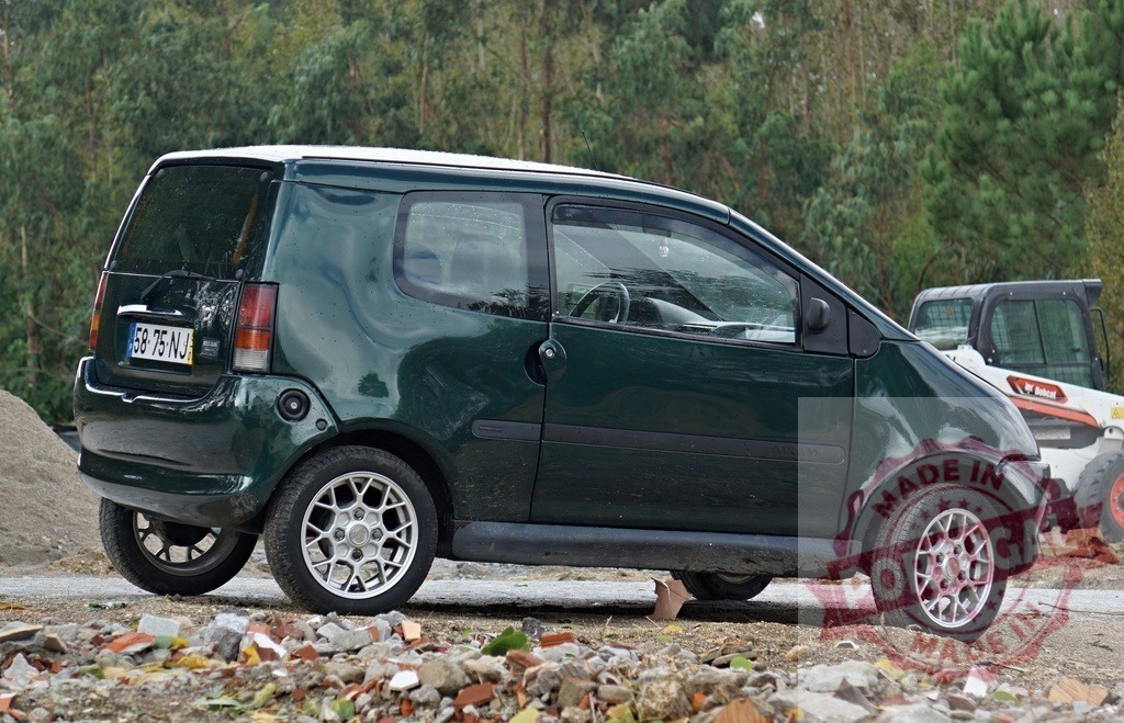 Ligier microcar parked on dusty construction site | Green Ligier microcar parked on a construction site with dirt and debris - Realisiert mit Pictrs.com