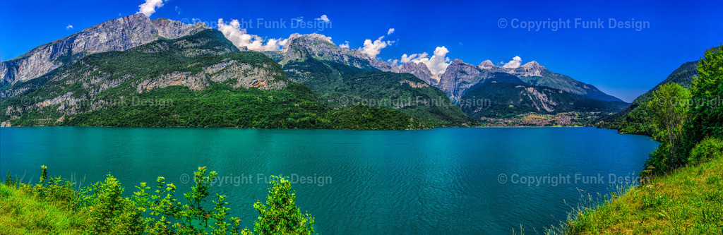 Molvenosee Panorama – Trentino, Italien | Ein weites Panorama über den Molvenosee mit intensiv blaugrünem Wasser und markanter Bergkulisse im Hintergrund. Die klare Sommerstimmung und die ruhige Wasserfläche machen das Motiv perfekt als hochwertiges Landschaftsbild für Wohn- und Arbeitsräume.