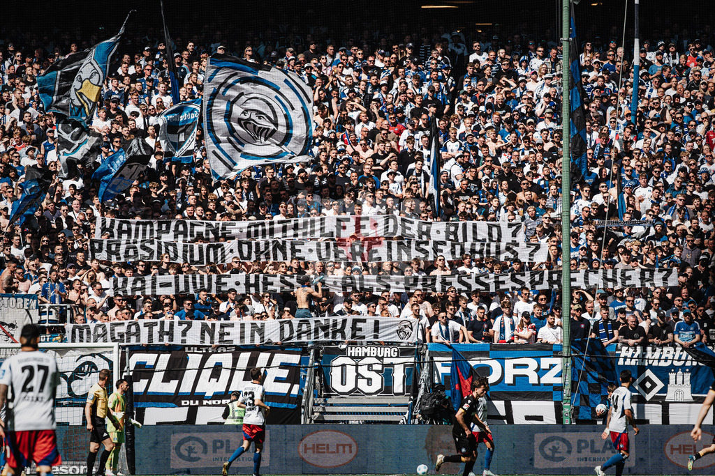 Fußball | Männer | Saison 2024/2025 | 2. Fußball-Bundesliga | 31. Spieltag | Hamburger SV vs. Karlsruher SC | 27.04.2025 | HSV Fans auf der Nordtribüne mit einem Banner Transparent: Kampagne mithilfe der Bild? Präsidium ohne Vereinsfokus? Kai-Uwe-Hesse als Pressesprecher? Magath? Nein, Danke!