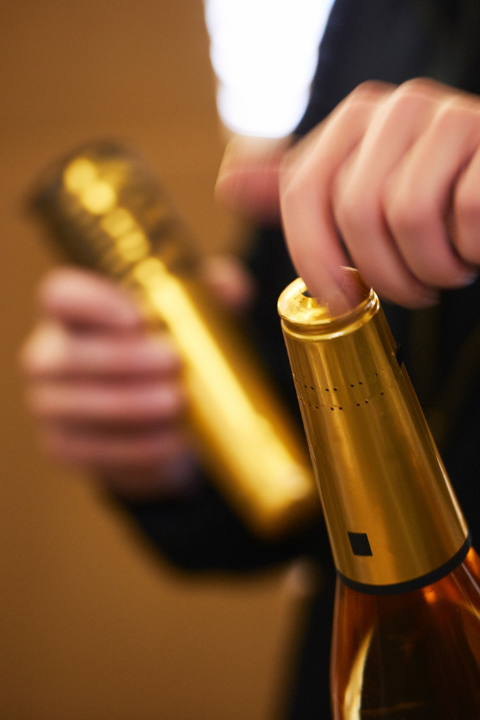 Sektkellerei Szigeti | Gols, Austria - February 19, 2018: Sektkellerei Szigeti; Sektflaschen werden von einem Mitarbeiter mit Sekt-Kappen bestückt. - Realisiert mit Pictrs.com