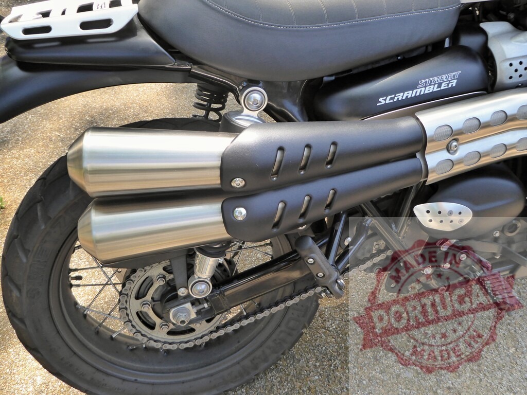 Triumph Street Scrambler exhaust pipes and rear wheel detail | Close-up of the exhaust pipes and rear wheel of a Triumph Street Scrambler motorcycle, highlighting its custom design and features - Realized with Pictrs.com