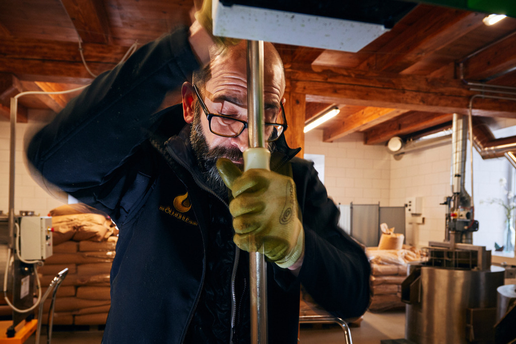 Die Ölmühle | Markt Allhau, Austria - February 09, 2018: Die Ölmühle; Herr Karl Grossschedl  befüllt die hydraulische Ölpresse mit Kernölbrei. - Realisiert mit Pictrs.com