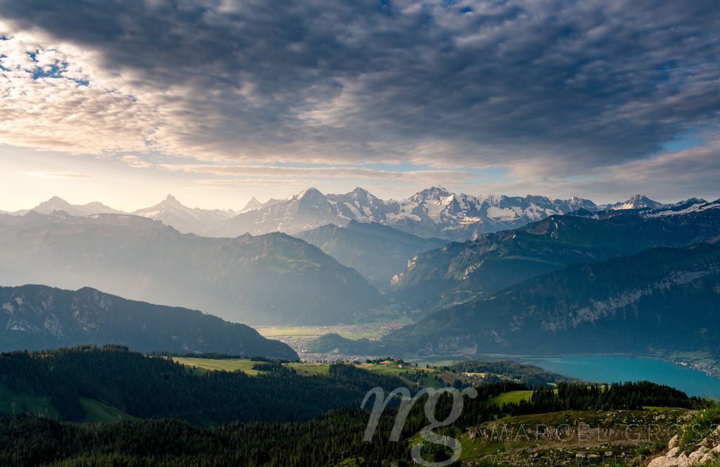 Aussicht auf Interlaken, Lauterbrunnental und Eiger, Mönch und Jungfrau mit dramatischen Sonnenstrahlen | Die ideale Geschenkidee für Naturliebhaber. Naturbilder von Marcel Gross Photography für ihr Zuhause in den verschiedensten Formaten und Materialien. - Realisiert mit Pictrs.com