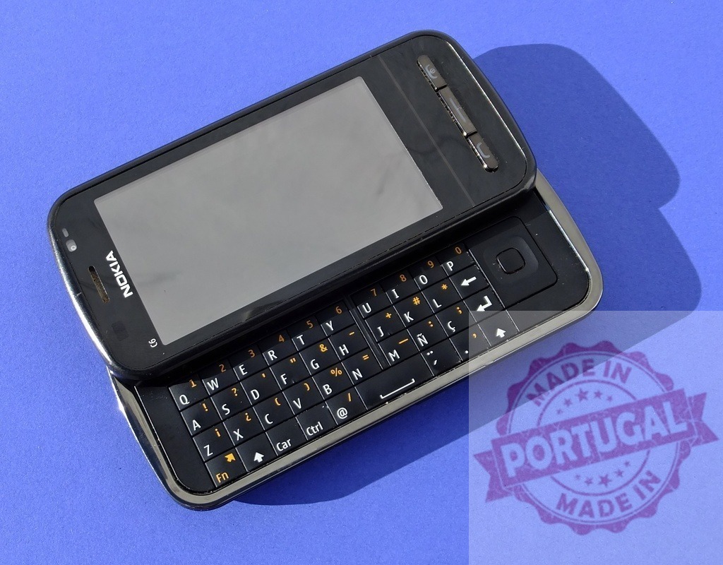 Nokia 6760 slide phone showing keyboard and screen on blue background | Old Nokia 6760 slide cellular phone with keyboard and screen visible, lying on a blue background - Realisiert mit Pictrs.com