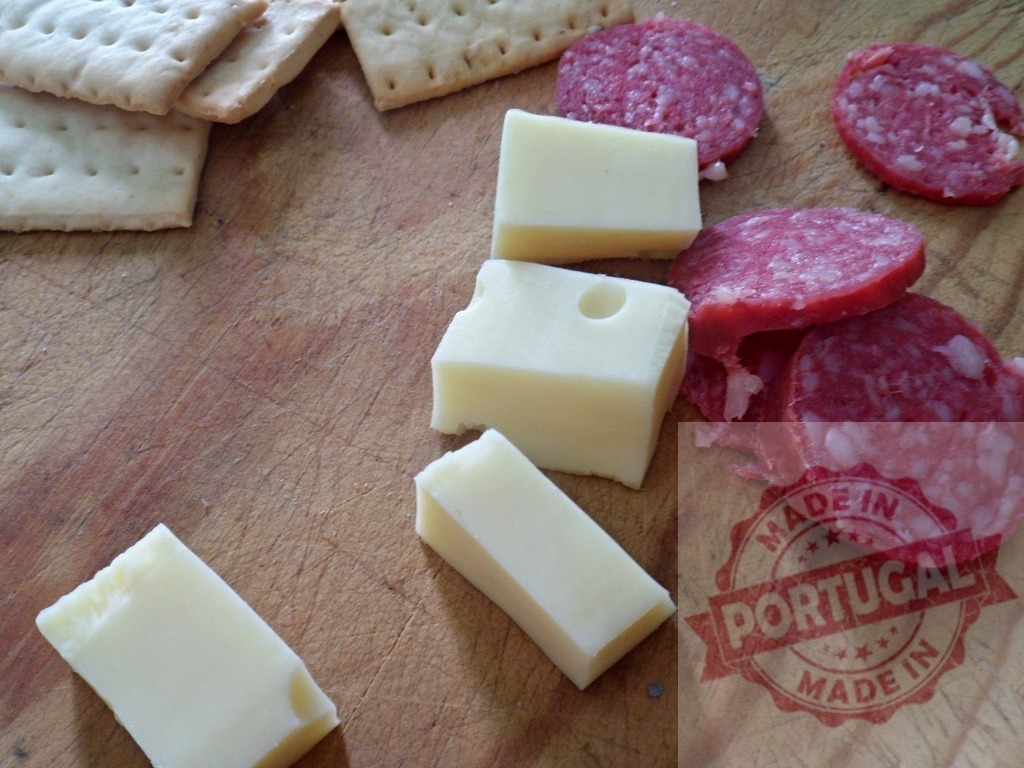 Cheese, salami, crackers on wooden board | Cheese, salami, and crackers arranged on a rustic wooden cutting board as an appetizers - Realisiert mit Pictrs.com