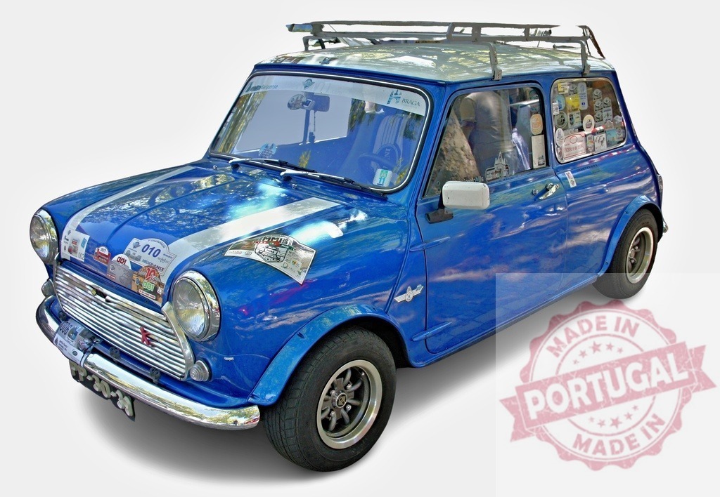 Classic blue Mini Cooper parking, showing travel stickers on its windows | Vintage Mini Cooper car with stickers from various locations parked, showcasing a passion for travel and adventure - Realized with Pictrs.com