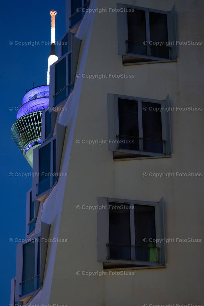Rheinturm am Abend vom Medienhafen in Düsseldorf | Der Rheinturm im Medienhafen von Düsseldorf am Abend. - Realisiert mit Pictrs.com