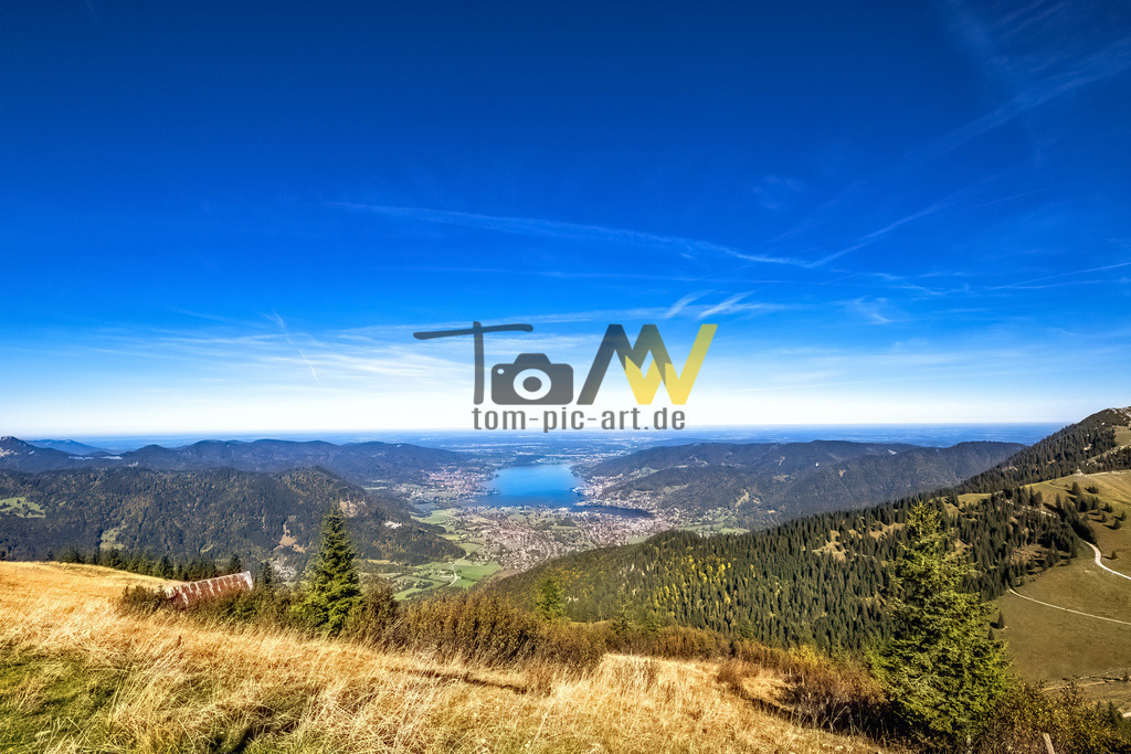 Panoramablick auf den Tegernsee | Das Bild zeigt den Tegernsee, einen See in den bayerischen Voralpen, etwa 50 Kilometer südlich von München. Der Tegernsee liegt im Landkreis Miesbach in Oberbayern. Er gilt als eines der saubersten Gewässer Bayerns, da bereits in den 1960er Jahren eine durchgängige Ringkanalisation um den See geschaffen wurde. Der See ist Eigentum des Freistaates Bayern und wird von der Bayerischen Verwaltung der staatlichen Schlösser, Gärten und Seen verwaltet. Die Gemeinden Gmund, Rottach-Egern, Bad Wiessee, Kreuth und die Stadt Tegernsee haben Anteile am Ufer.  - Realisiert mit Pictrs.com