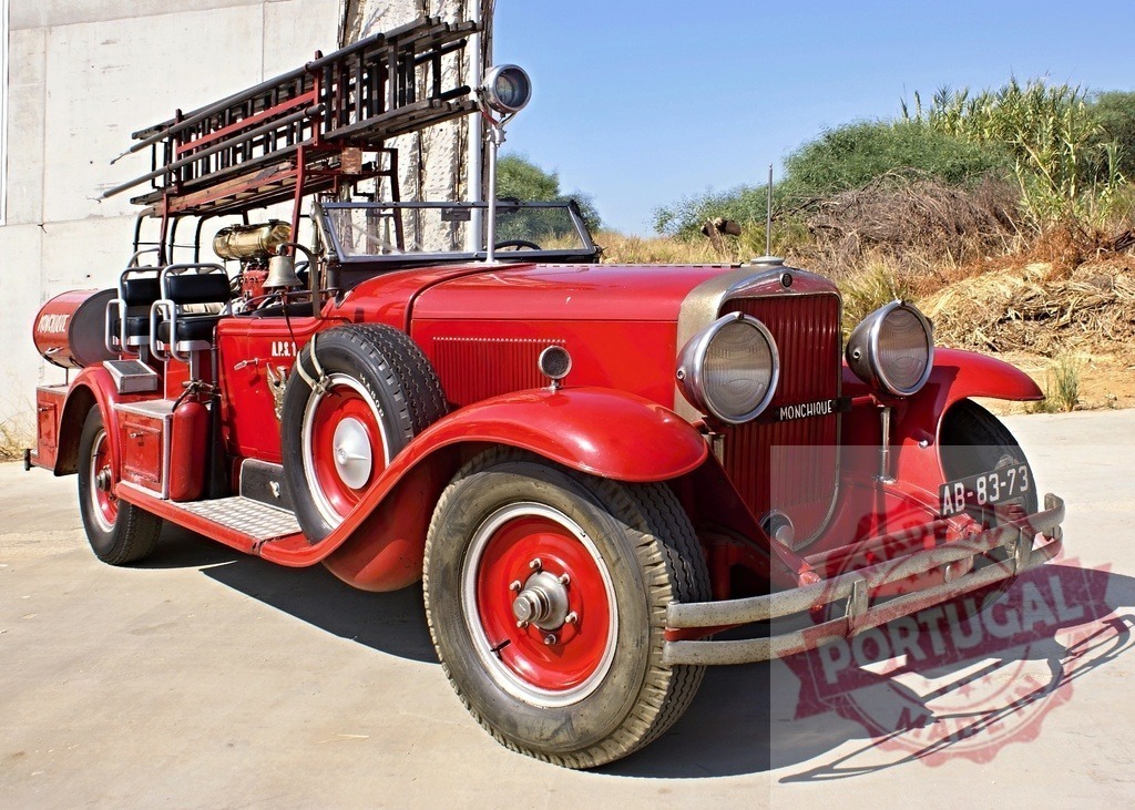 Vintage red fire truck parked outdoors on sunny day | Restored antique fire engine with ladders and equipment ready to respond - Realized with Pictrs.com