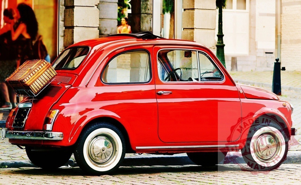 Red Fiat 500 vintage car with picnic basket | Red vintage Fiat 500 car with a picnic basket on the luggage rack in a European city street - Realized with Pictrs.com