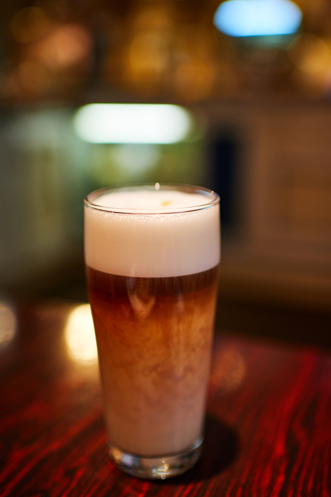 Cafe Vollpension in der Schleifmühlgasse | Wien, Austria - January 24, 2019: Cafe Vollpension in der Schleifmühlgasse, ein Glas Cafe Latte auf dem Tisch. - Realisiert mit Pictrs.com