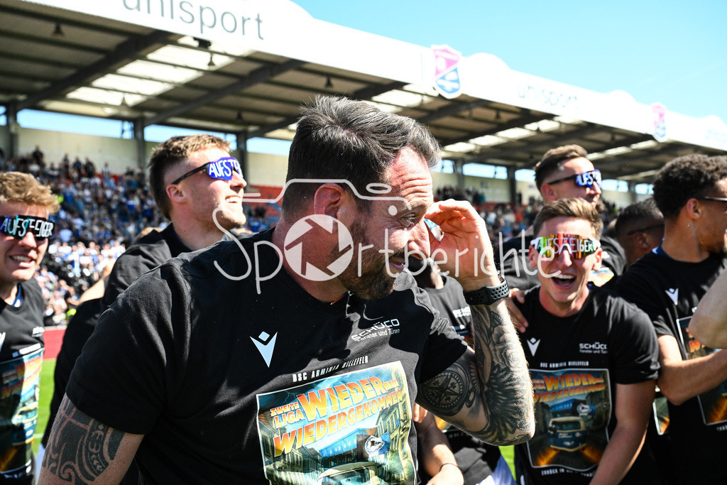 SpVgg Unterhaching - Arminia Bielefeld | die Mannschaft aus Bielefeld feiert zusammen mit den Fans dein Sieg und den Aufstieg in Unterhaching / Bierdursche / Bier / Freude / Happy / Gluecklich / 3. Liga: SpVgg Unterhaching - Arminia Bielefeld, Uhlsport Park am 11.05.2025 / Michel KNIAT Trainer Arminia Bielefeld