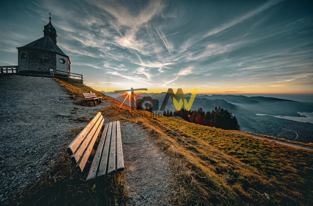 Die Kirche auf dem Wallberg bei Sonnenaufgang----Tegernsee | Das Bild zeigt die Wallbergkirchlein (St. Anna Kapelle) auf dem Wallberg in Bayern bei Sonnenaufgang oder Sonnenuntergang.Der Wallberg ist ein bekannter Berg am Tegernsee in Bayern und thront am Südufer des Sees, direkt hinter der Ortschaft Rottach-Egern. Die Kapelle befindet sich auf 1.722 Metern Höhe und ist ein beliebtes Ziel für Wanderer und Touristen. Die Wanderung von der Talstation der Wallbergbahn bis zum Gipfel dauert etwa 2,5 bis 3 Stunden. Der Ort ist bekannt für seine malerische Aussicht auf den Tegernsee und die umliegenden Alpen. - Realisiert mit Pictrs.com