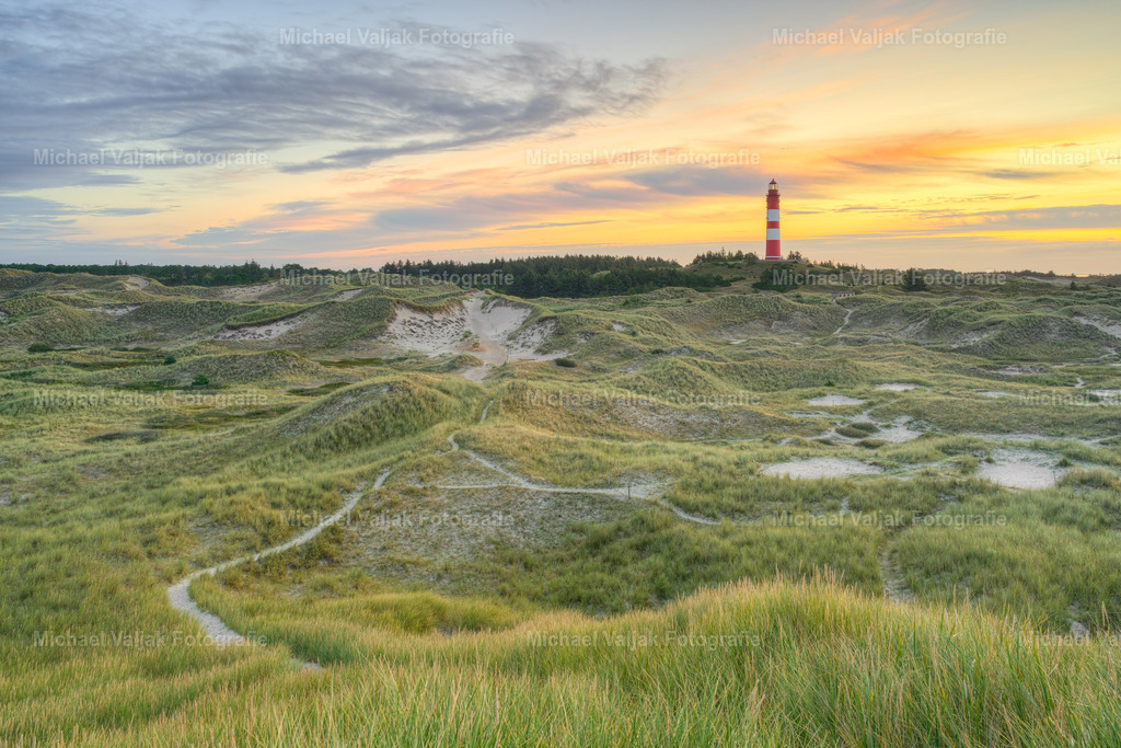 Leuchtturm auf Amrum bei Sonnenaufgang | Der Leuchtturm auf Amrum, bekannt als Amrumer Leuchtturm, ist ein markantes Wahrzeichen der Nordseeinsel. Bei Sonnenaufgang bietet er ein besonders malerisches Bild, wenn die ersten Strahlen des Tages den Himmel in ein warmes Farbenspiel tauchen und die Landschaft in ein sanftes Licht hüllen. Dieses Naturschauspiel zieht Jahr für Jahr zahlreiche Besucher an, die die ruhige Schönheit und die historische Bedeutung des Leuchtturms schätzen. Der Anblick des Leuchtturms bei Tagesanbruch ist ein unvergessliches Erlebnis, das die harmonische Verbindung von Natur und Kultur auf Amrum widerspiegelt. - Realisiert mit Pictrs.com