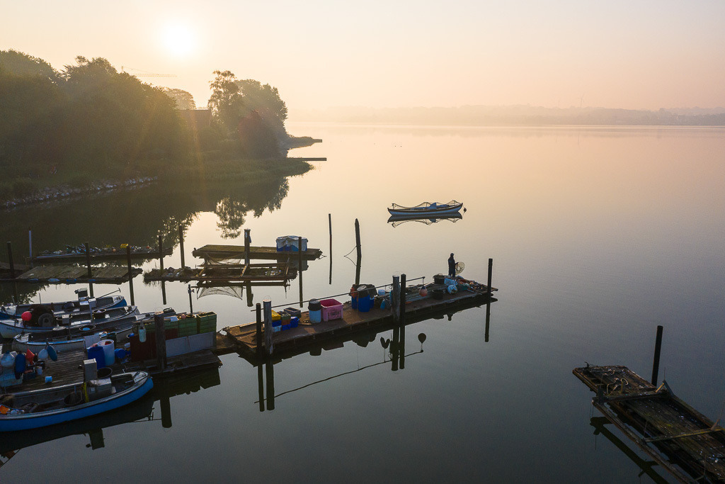 zeitenwende-farbe-01-03 | In der Fischersiedlung Holm in Schleswig an der Schlei: Kurz nach Sonnenaufgang prüft der Fischer Christian Ross seine Fanggeräte. Christian Ross ist einer der letzten Fischer an der Schlei. Schon seit mehreren Jahrhunderten lebten und fischten seine Vorfahren hier. - Realisiert mit Pictrs.com